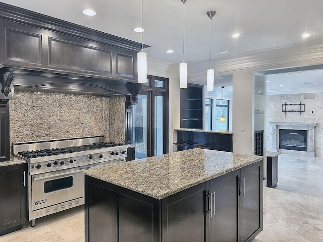 kitchen featuring a kitchen island, decorative light fixtures, dark stone countertops, range with two ovens, and ornamental molding