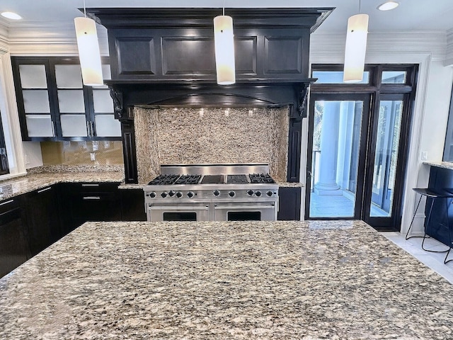 kitchen featuring dark stone countertops, double oven range, ornamental molding, and custom range hood