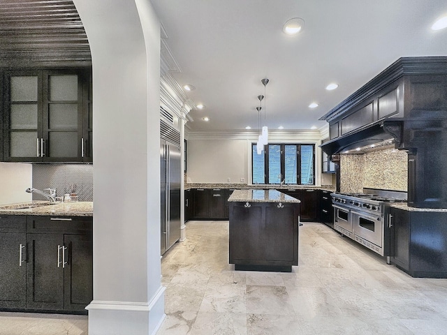 kitchen with pendant lighting, sink, crown molding, high quality appliances, and a kitchen island