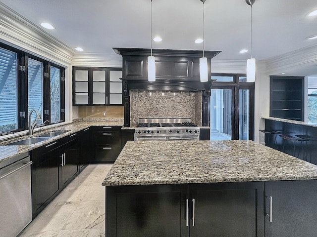 kitchen featuring hanging light fixtures, a kitchen island, sink, and appliances with stainless steel finishes