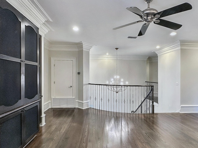 spare room featuring crown molding, ceiling fan with notable chandelier, and dark hardwood / wood-style floors