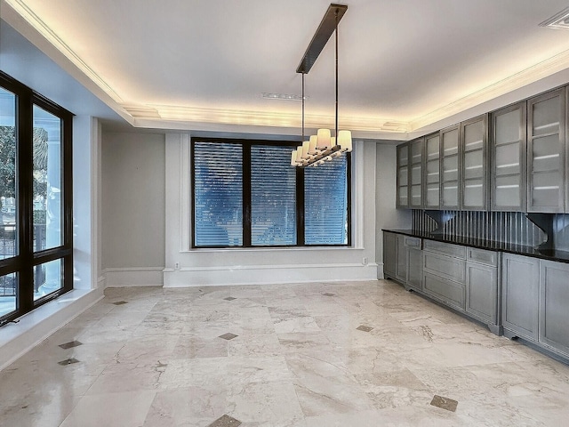 unfurnished dining area featuring crown molding and a raised ceiling