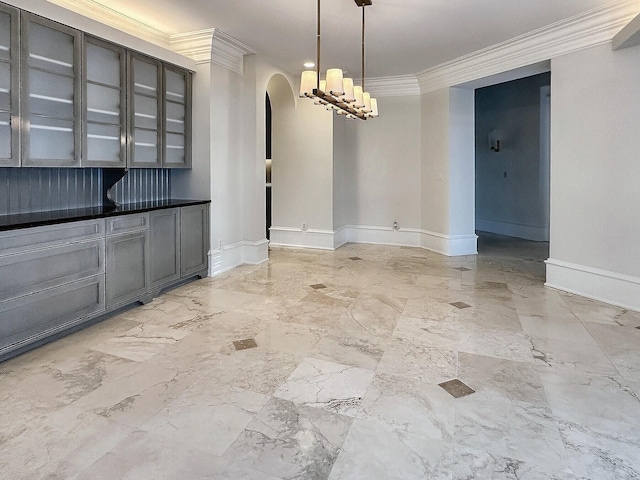 unfurnished dining area with ornamental molding and a chandelier