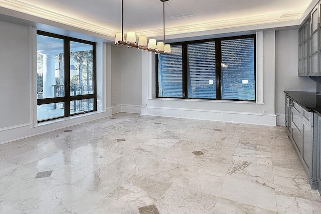 unfurnished dining area featuring a notable chandelier and crown molding