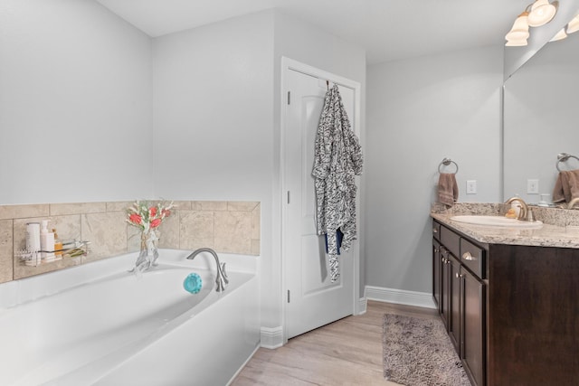 bathroom featuring a tub, hardwood / wood-style flooring, and vanity