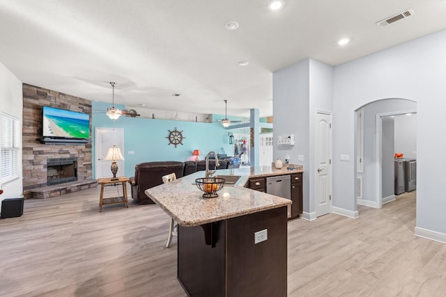 kitchen with decorative light fixtures, sink, stainless steel dishwasher, and a kitchen breakfast bar