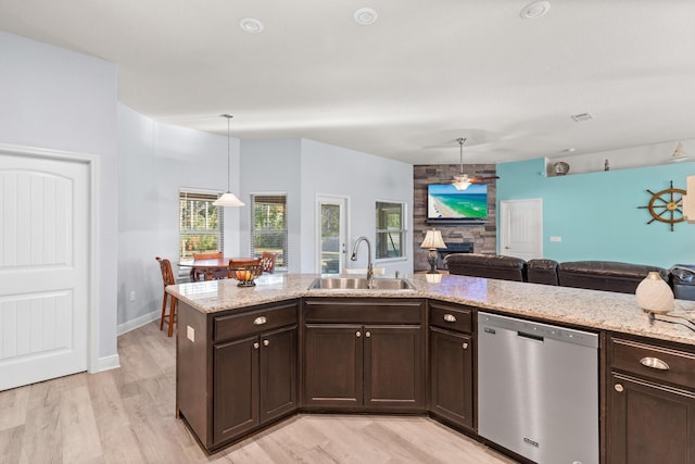 kitchen with pendant lighting, sink, light wood-type flooring, stainless steel dishwasher, and dark brown cabinets