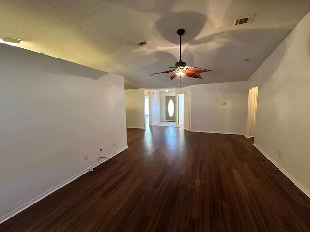 unfurnished living room with ceiling fan, dark wood-type flooring, and a textured ceiling