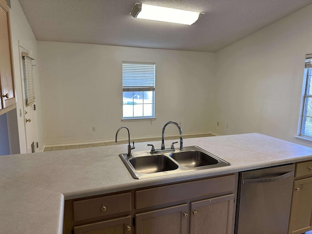 kitchen featuring a textured ceiling, dishwasher, and sink