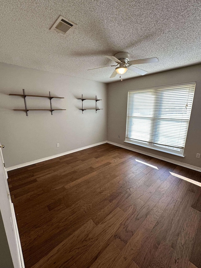 spare room featuring a textured ceiling, dark hardwood / wood-style floors, and ceiling fan