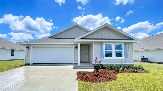 view of front of property with a garage, central air condition unit, and a front yard