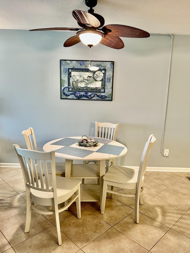 dining space with tile patterned floors, ceiling fan, and a textured ceiling