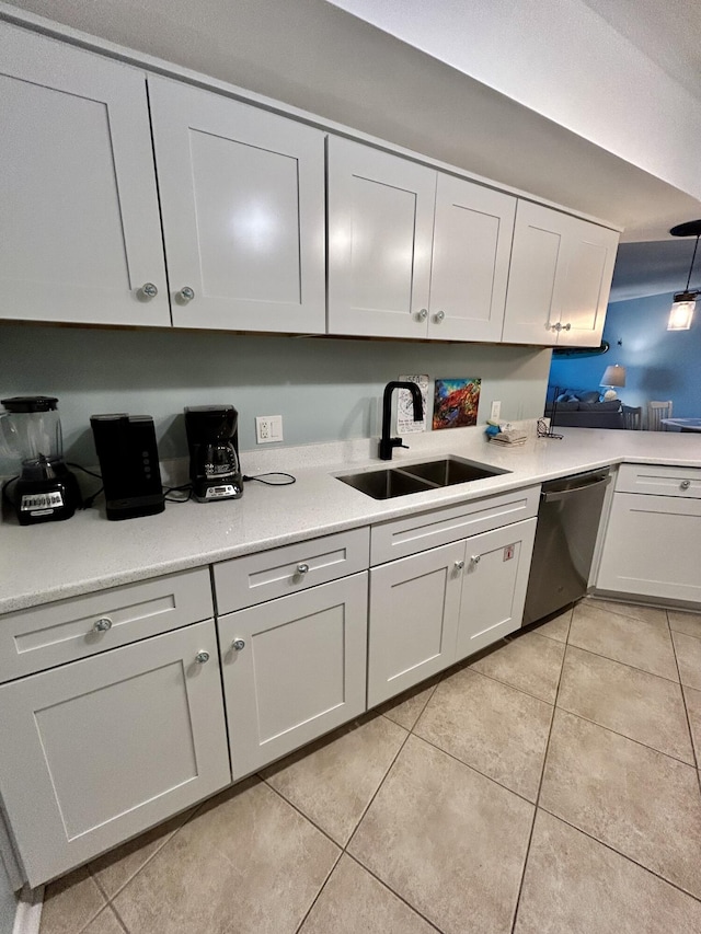 kitchen with stainless steel dishwasher, white cabinetry, sink, and light tile patterned floors