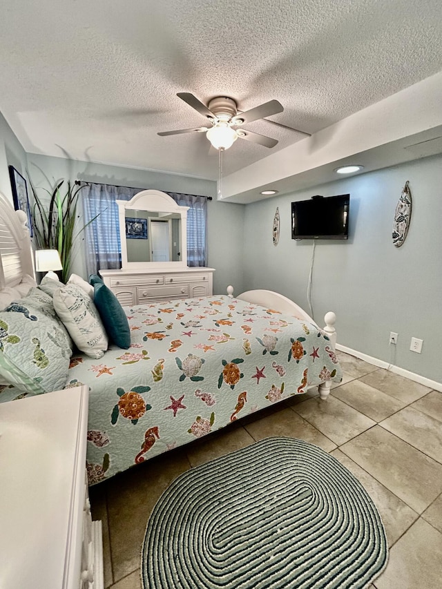 tiled bedroom with ceiling fan and a textured ceiling