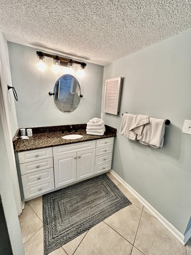 bathroom with tile patterned flooring, vanity, and a textured ceiling