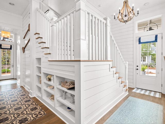 entrance foyer featuring a healthy amount of sunlight, dark hardwood / wood-style flooring, ornamental molding, and wooden walls