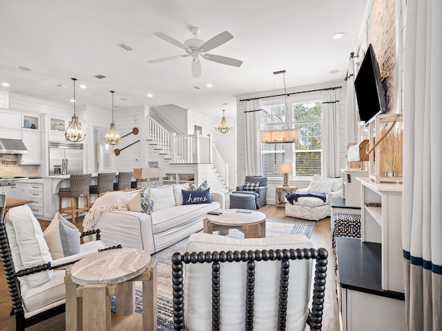 living room featuring ceiling fan with notable chandelier and dark hardwood / wood-style floors