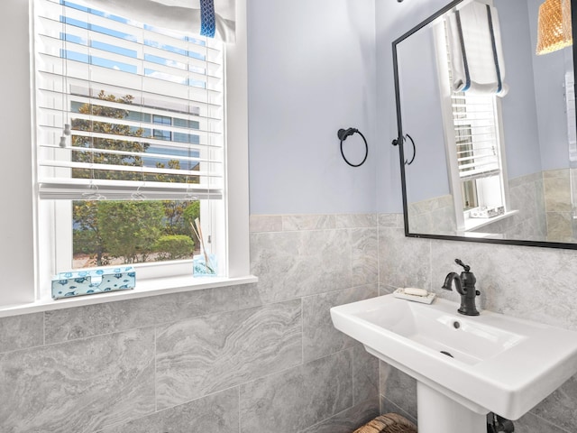 bathroom with sink and tile walls