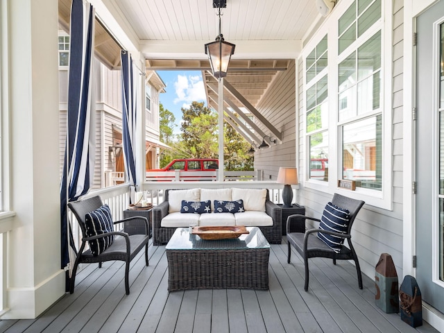 wooden terrace with an outdoor living space