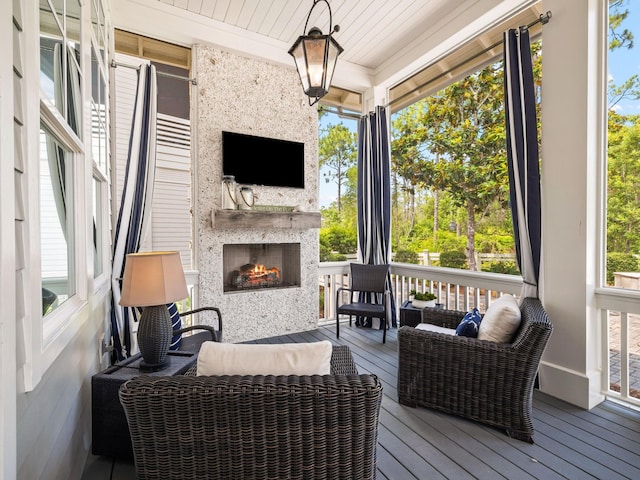 sunroom / solarium with wooden ceiling, a fireplace, and a wealth of natural light