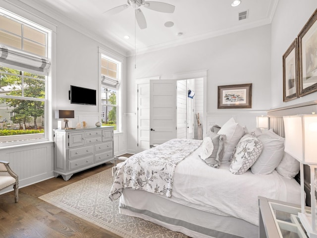 bedroom with ceiling fan, dark hardwood / wood-style floors, crown molding, and multiple windows