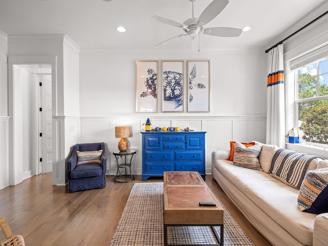 living room featuring ceiling fan, wood-type flooring, and crown molding