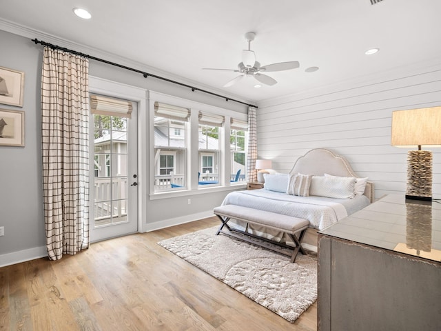 bedroom featuring ceiling fan, crown molding, wood walls, access to outside, and light wood-type flooring