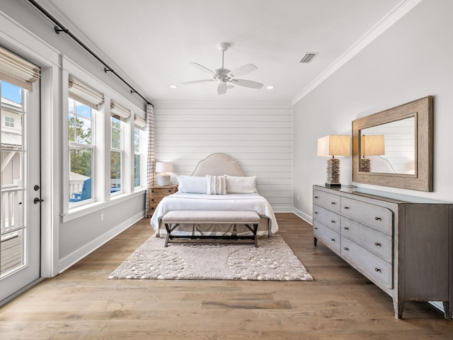 bedroom featuring hardwood / wood-style flooring, ceiling fan, crown molding, and multiple windows