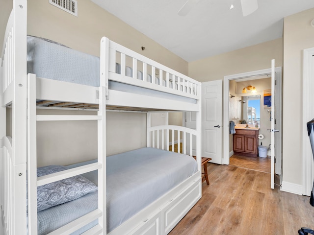 bedroom featuring ensuite bath, ceiling fan, and light wood-type flooring