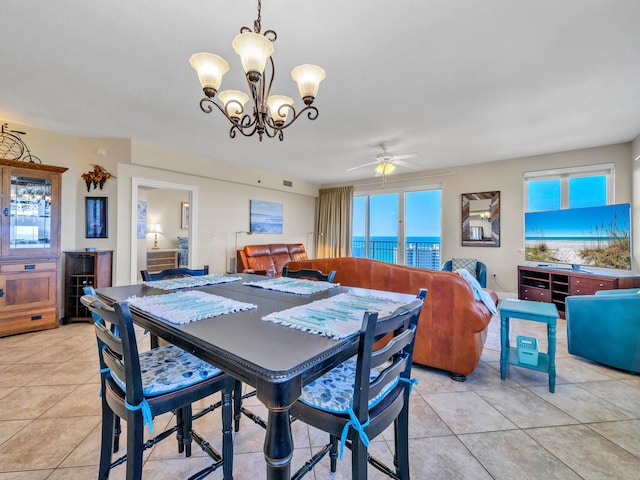 dining area featuring light tile patterned floors and ceiling fan with notable chandelier