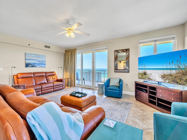 living room featuring ceiling fan, plenty of natural light, and light tile patterned flooring