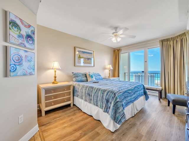 bedroom with access to outside, a water view, ceiling fan, and hardwood / wood-style flooring