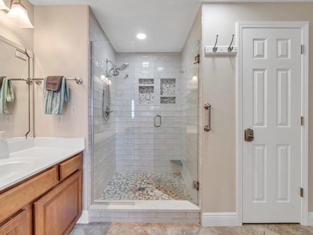 bathroom with tile patterned flooring, vanity, and a shower with door