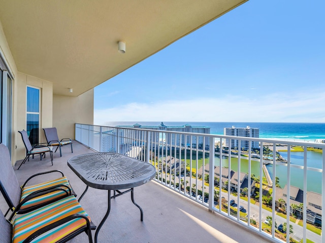 balcony with a water view and a view of the beach