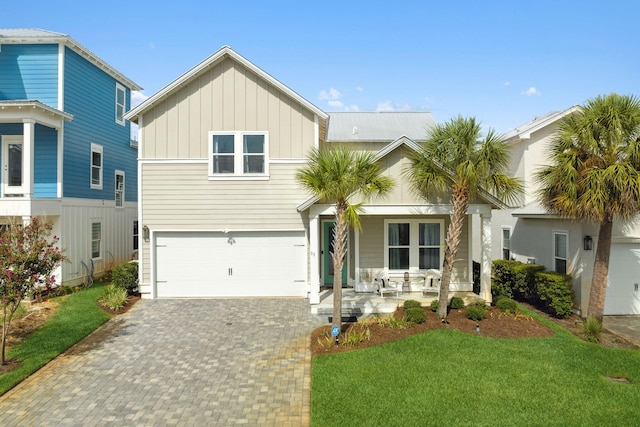 view of front facade featuring covered porch, a garage, and a front lawn