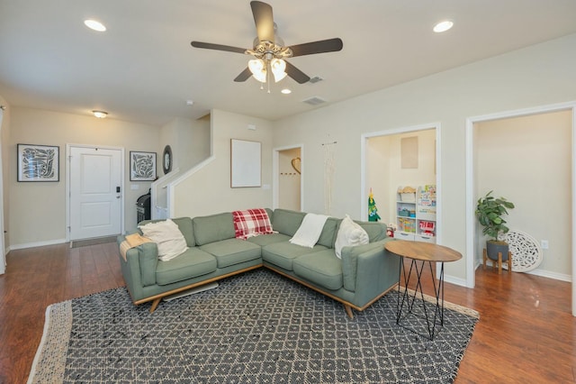 living room with dark hardwood / wood-style flooring and ceiling fan