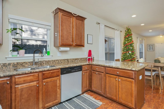 kitchen with kitchen peninsula, light stone counters, sink, dishwasher, and dark hardwood / wood-style floors