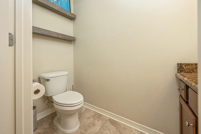 bathroom with tile patterned flooring, vanity, and toilet