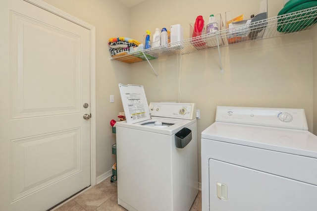 washroom with washing machine and dryer and light tile patterned flooring