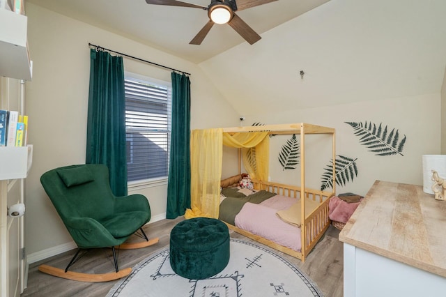 bedroom with ceiling fan, vaulted ceiling, and light wood-type flooring