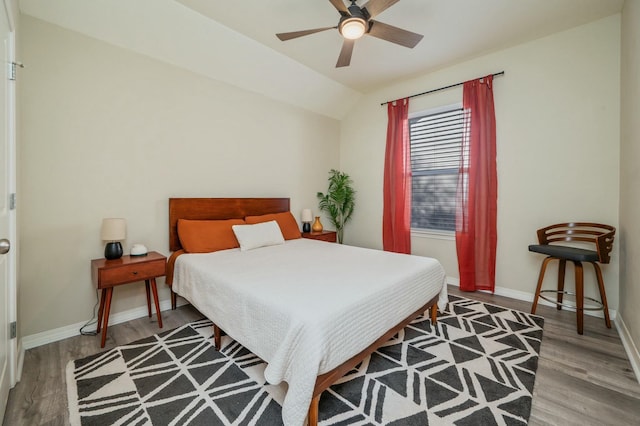 bedroom with ceiling fan, wood-type flooring, and vaulted ceiling