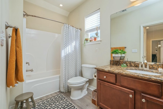 full bathroom featuring hardwood / wood-style floors, vanity, toilet, and shower / bath combo