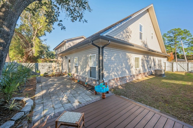 exterior space with a yard, a wooden deck, and central AC