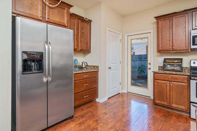 1305 Finck Rd, Niceville, FL 32578 - kitchen with appliances with stainless steel finishes, stone counters, dark wood finished floors, and brown cabinetry