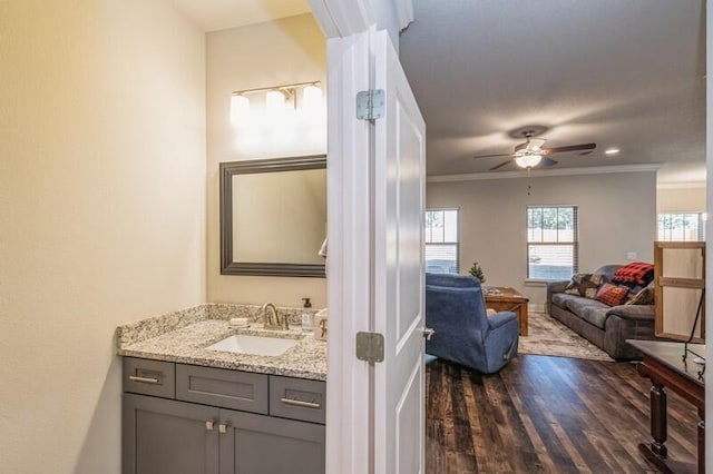 bathroom featuring ceiling fan, wood-type flooring, crown molding, and vanity