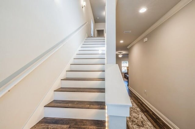 stairs with ceiling fan, ornamental molding, and hardwood / wood-style flooring