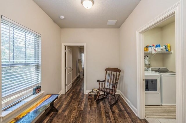 living area with washer and dryer, dark hardwood / wood-style flooring, and a textured ceiling