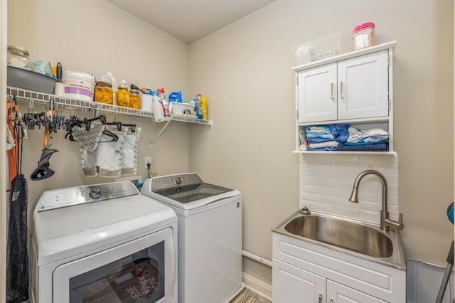 laundry room with washer and dryer, cabinets, and sink