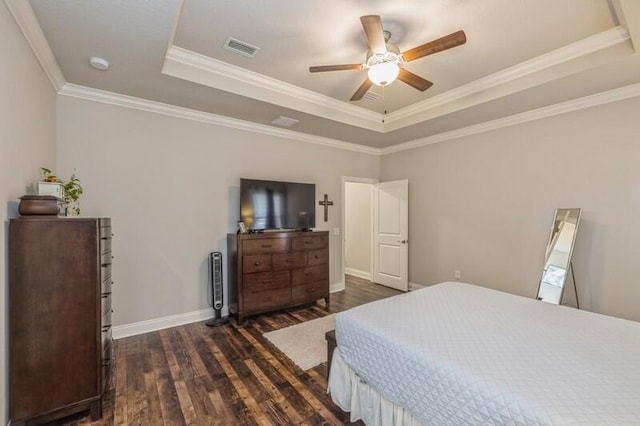 bedroom featuring dark hardwood / wood-style flooring, a tray ceiling, ceiling fan, and crown molding