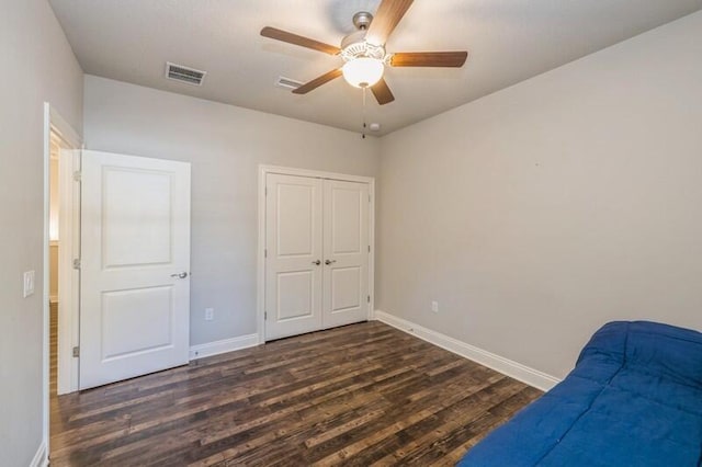 living area featuring dark hardwood / wood-style floors and ceiling fan